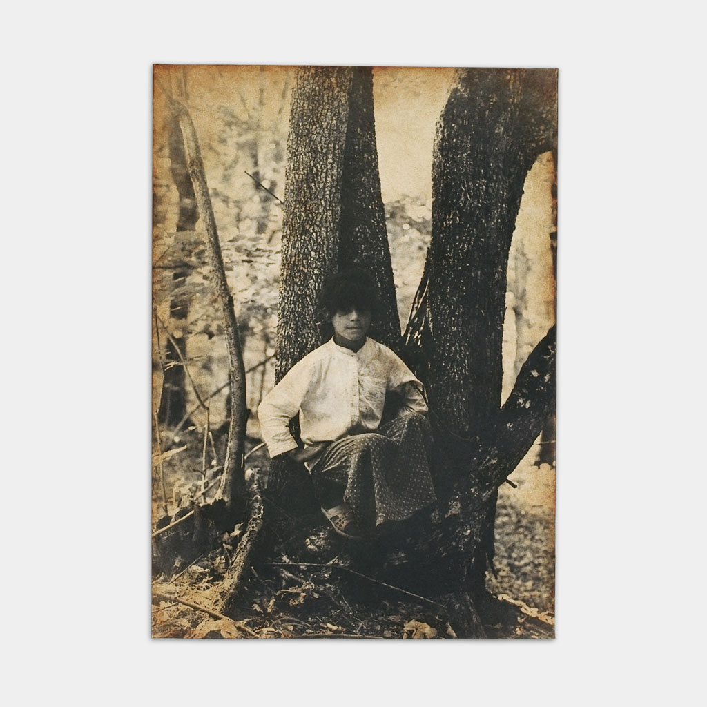 森の中で座るジプシーの少女の写真（正面）